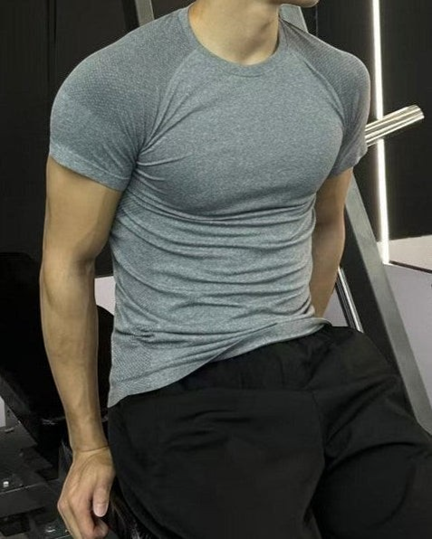 ASCEND gray seamless compression short sleeve tee on a fit model in a gym setting
