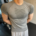 ASCEND gray seamless compression t-shirt with scale pattern detail worn by a muscular man in a gym setting