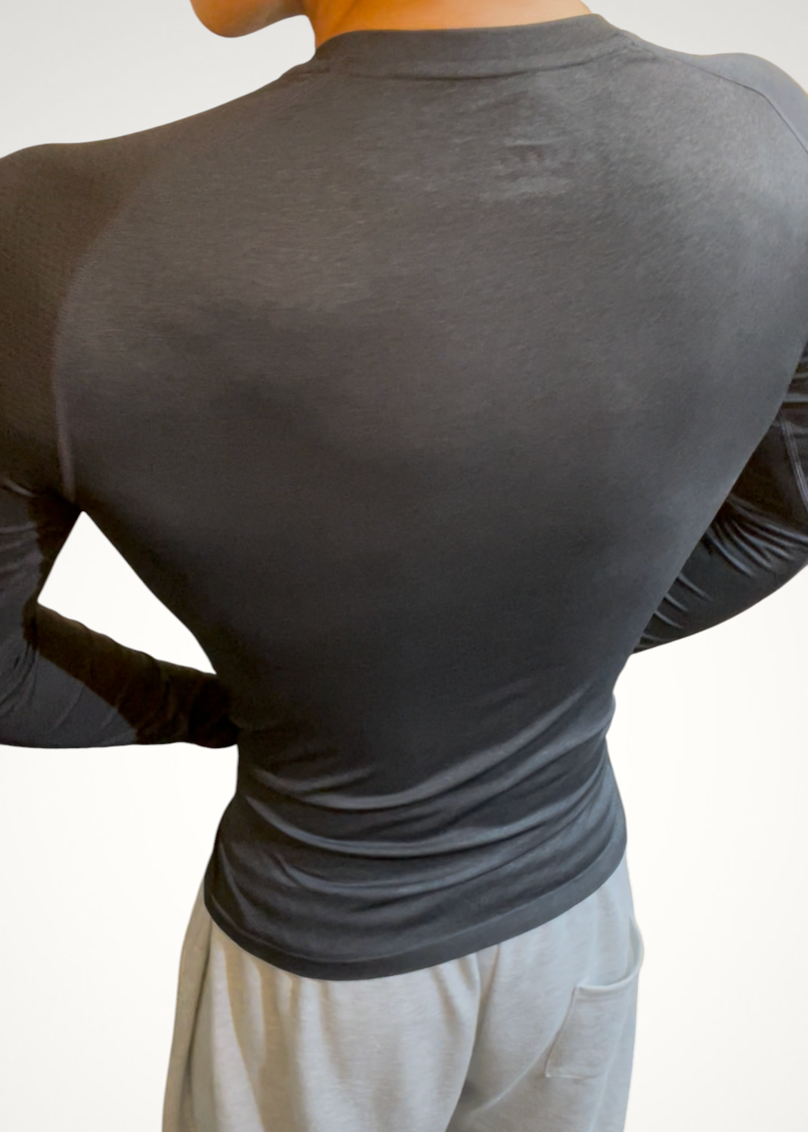 ASCEND black compression long sleeve tee with seamless shoulder detailing worn by a male model from the back view