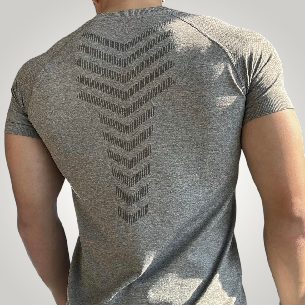 ASCEND gray seamless compression tee with a chevron pattern on the back, worn by a muscular model.