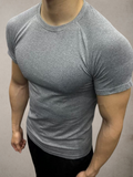 ASCEND gray seamless compression short sleeve tee with textured shoulder detailing on a muscular model in a gym