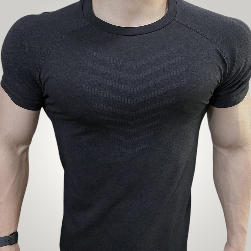 ASCEND black seamless compression t-shirt with athletic chest detailing worn by a muscular man in a gym