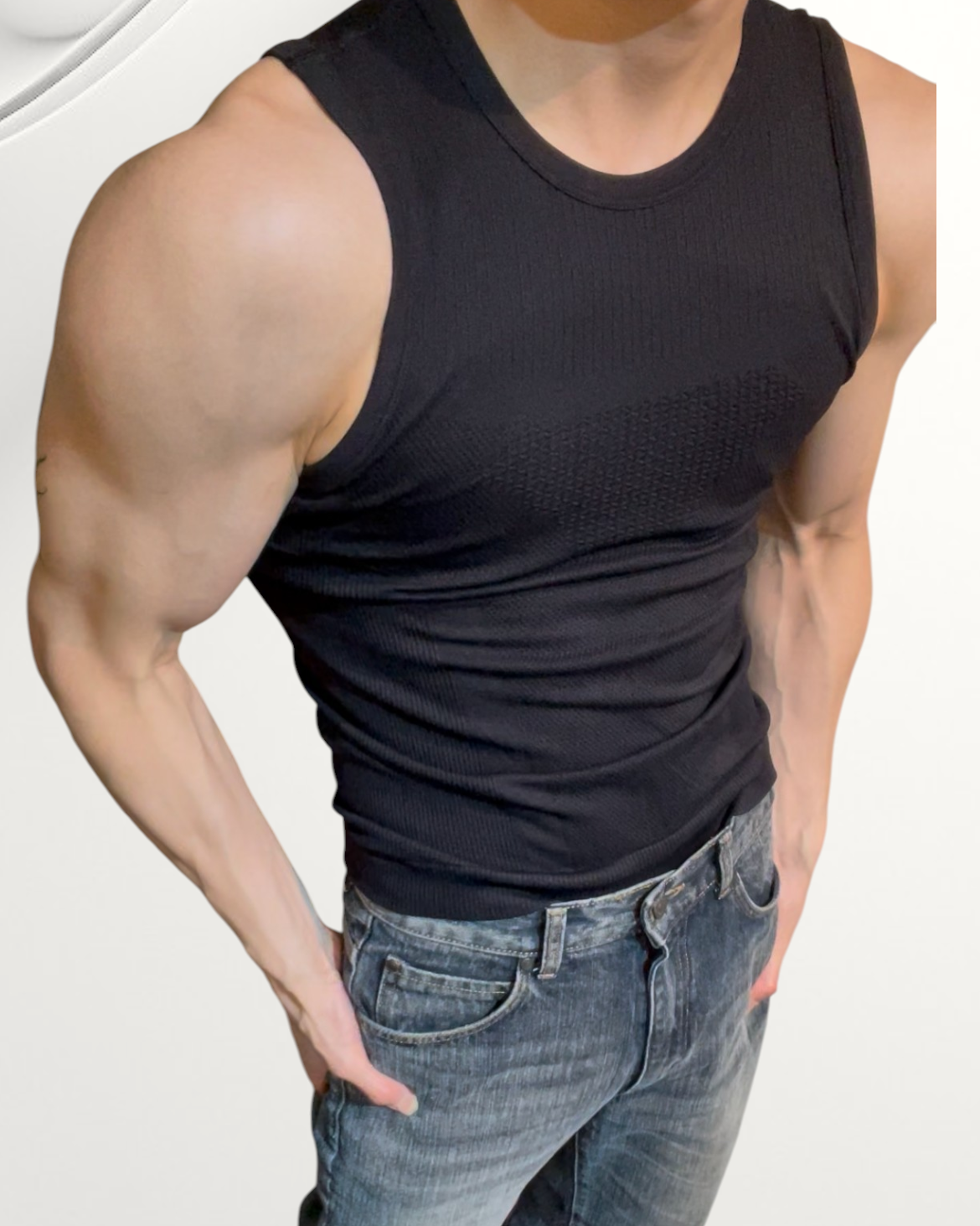 ASCEND black textured compression tank top worn by a muscular man with grey denim jeans