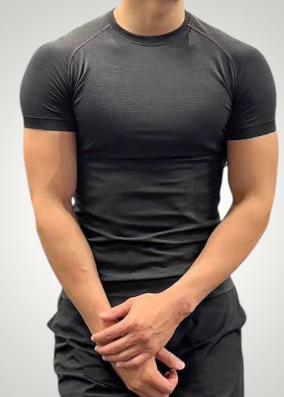ASCEND black seamless jacquard compression tee worn by a fit man in a gym setting